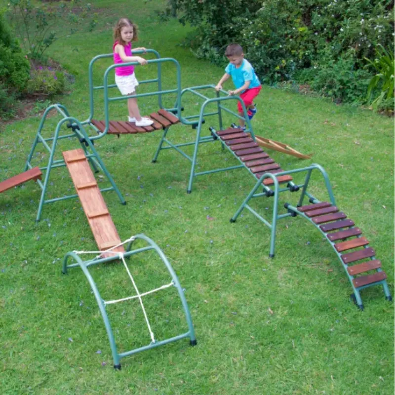 Children using freestanding outdoor climbers and jungle gyms for gross motor play in a preschool playground