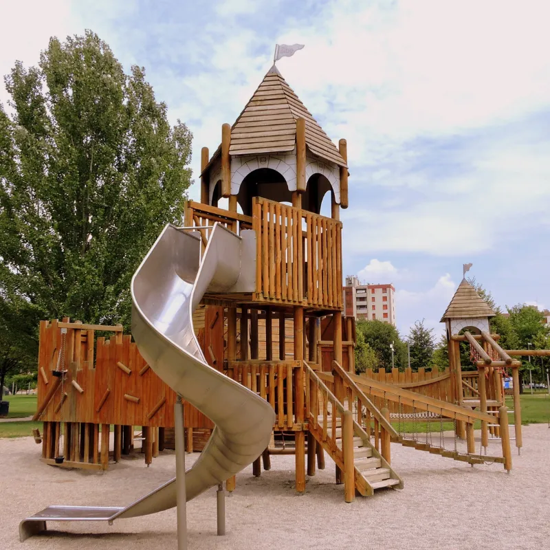 Custom wooden outdoor climbing playset with spiral slide and rope net for preschool gross motor development