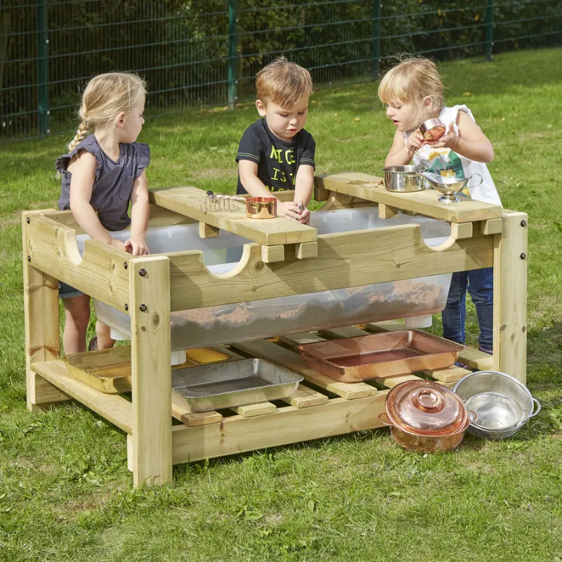 Children exploring natural materials at outdoor STEM sensory table with sorting trays in a preschool garden setting