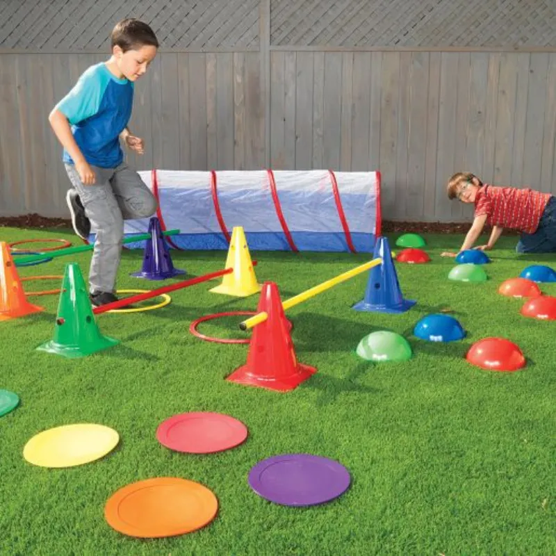Colorful obstacle course set with cones, hoops, tunnels and balance spots for preschool outdoor gross motor development