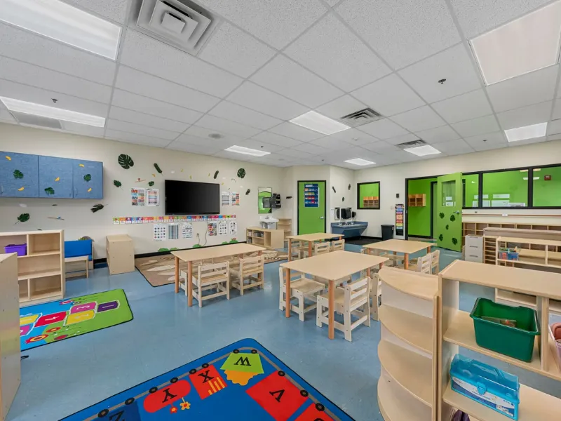 Kindergarten classroom with colourful tables, chairs and storage units