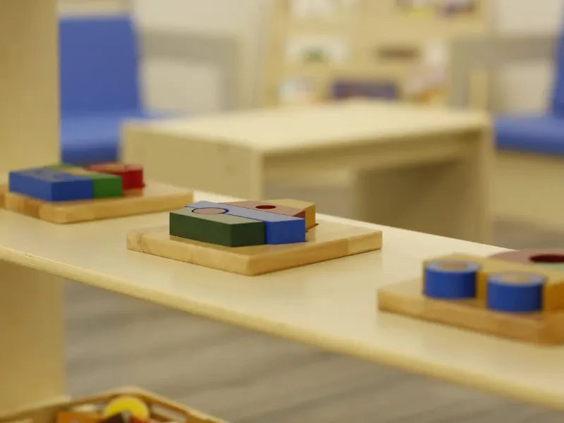 Natural wood Montessori classroom furniture with child-sized tables and chairs