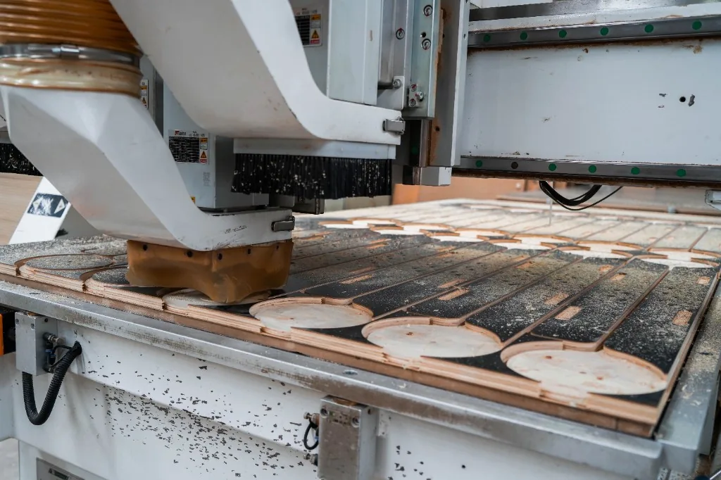 CNC cutter machining circular plywood parts for preschool furniture