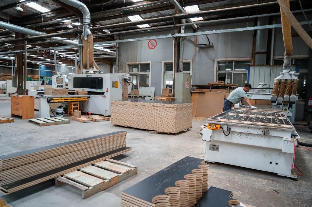 CNC machines and plywood stock on the West Shore factory floor in Dalian