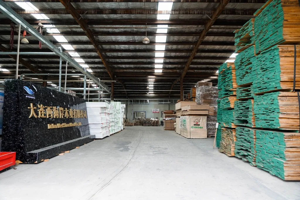 Dalian West Shore Wood warehouse with the company sign and stacked plywood ready for production