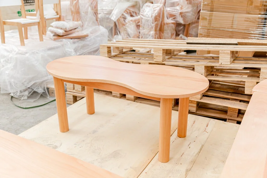 Solid beech peanut-shaped preschool table on a factory pallet