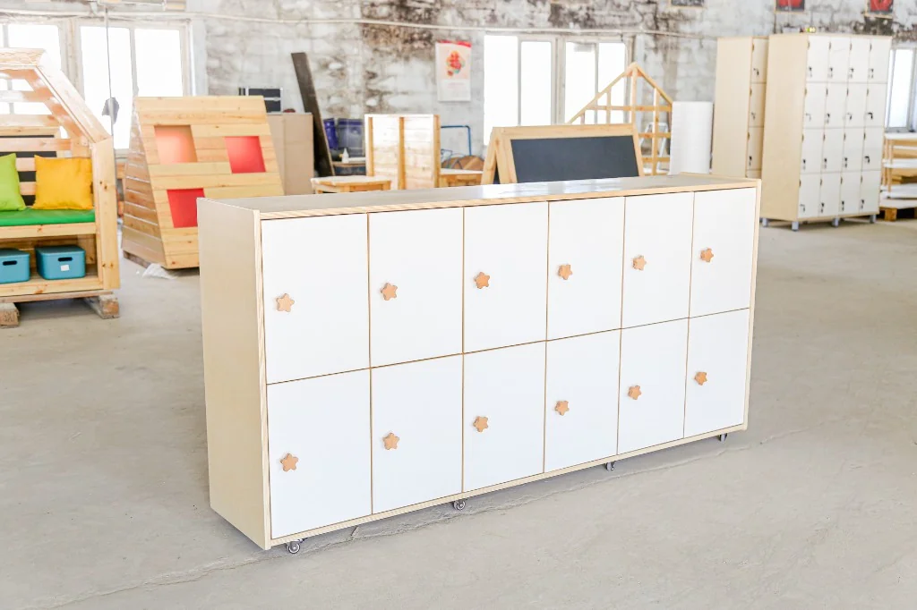 White 15-door preschool cubby locker with flower knobs and birch edges on casters in the factory
