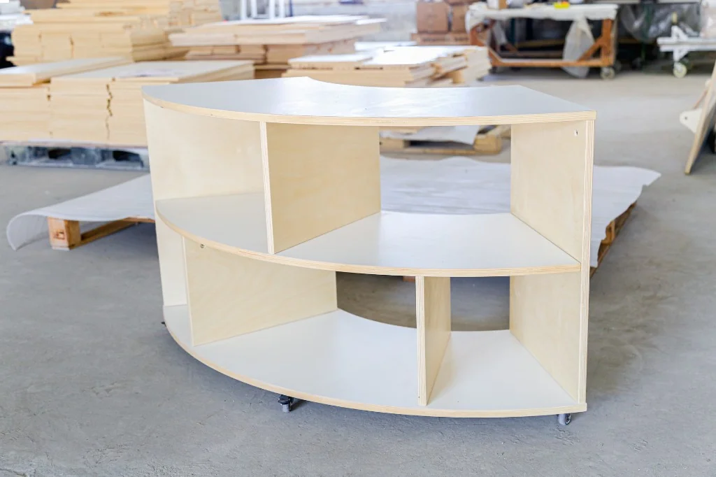 Large curved birch preschool corner storage unit with open cubbies on casters