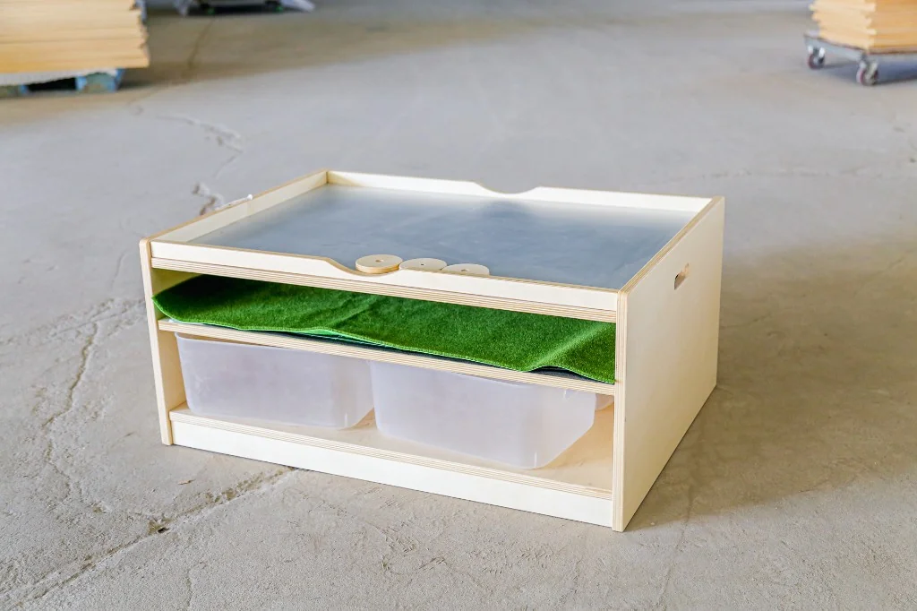 Birch preschool light table with a frosted top, green felt insert and two clear storage bins