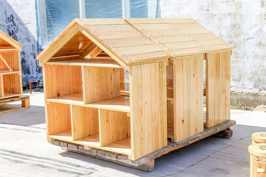 Solid pine house-shaped preschool cubby with open shelves and a pitched roof